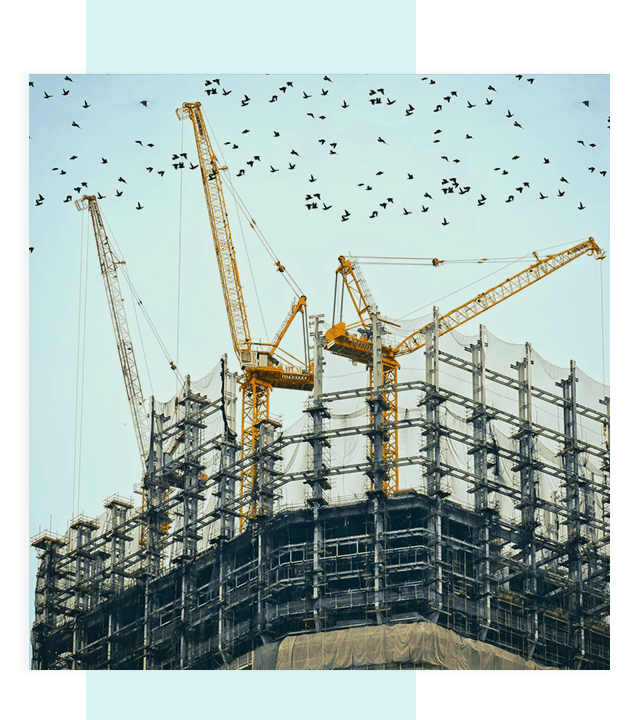Construction cranes on a construction site, managed by civil engineers.